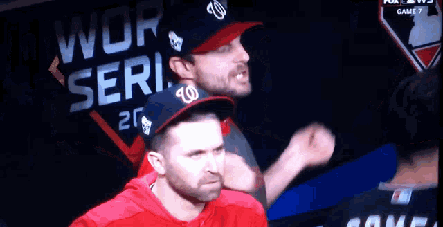 a man in a w hat is standing in front of a sign that says world series