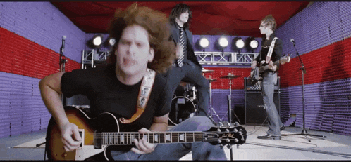 a man playing a guitar in a band with a strap that says ' alvarez ' on it