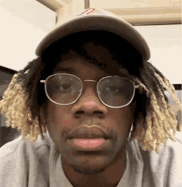 a man wearing glasses and a baseball cap with the letter o on it