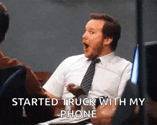 a man in a suit and tie is sitting at a table with his mouth open and the words `` started truck with my phone '' .