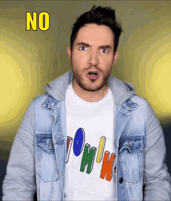 a man wearing a denim jacket and a t-shirt with the word tommy on it
