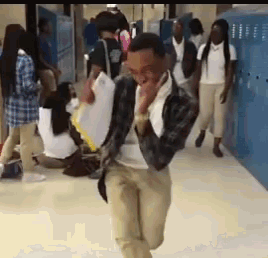 a man is running in a hallway with a group of people behind him