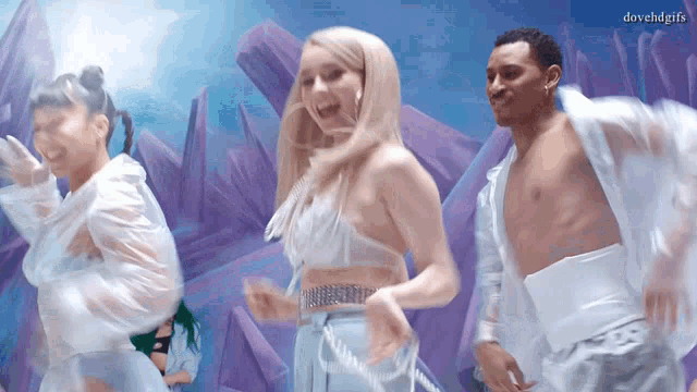 a group of people are dancing in front of purple crystals and the caption dovehdgifs