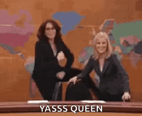two women are dancing on a stage and one of them is sitting on the floor .