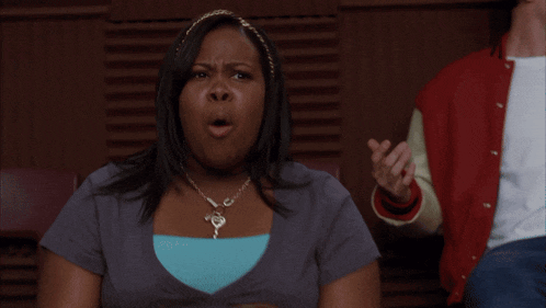 a woman wearing a necklace with a key on it is screaming