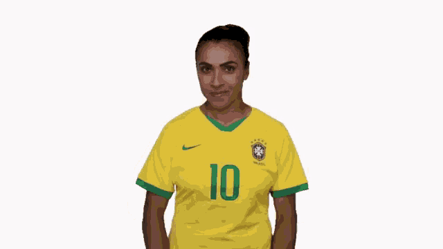 a woman wearing a yellow soccer jersey with the number 10 on it