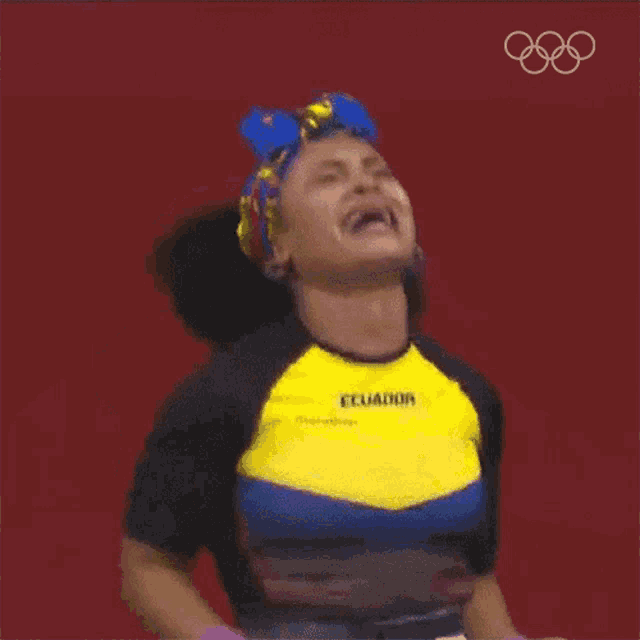 a woman wearing a shirt that says ecuador is raising her arms in the air