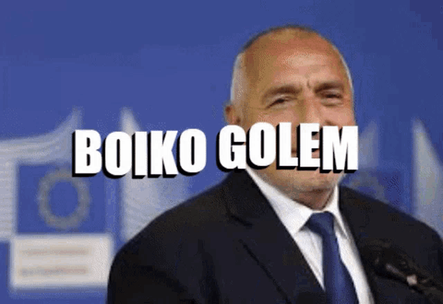 a man in a suit and tie stands in front of a microphone with the words boiko golem written on his face