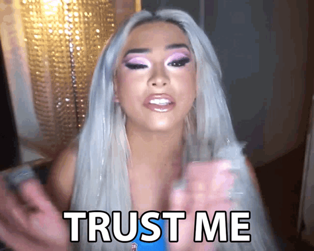 a woman with white hair and pink eye shadow says " trust me "