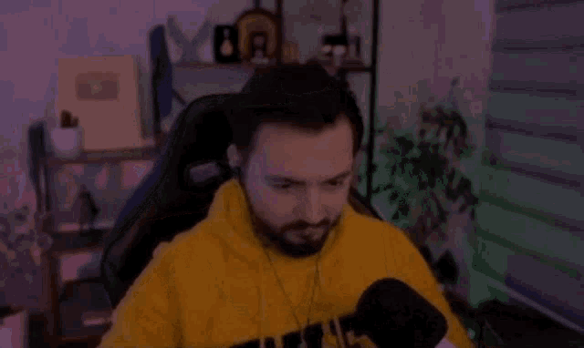a man is sitting in a chair in front of a microphone .