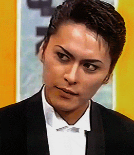 a man wearing a tuxedo and a white shirt is looking at something