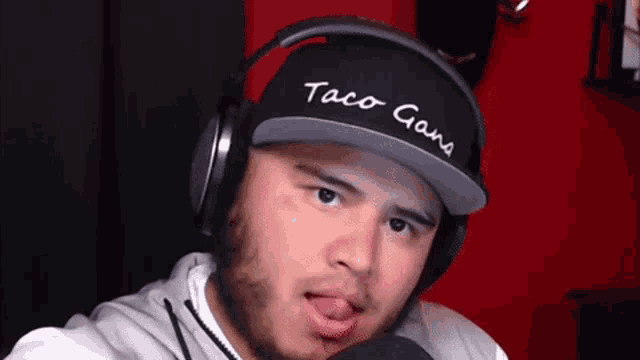 a man wearing headphones and a taco gang hat