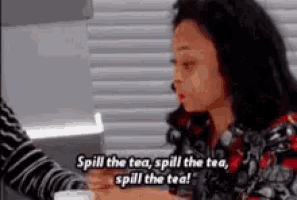a woman is sitting at a table with a cup of tea and talking to someone .