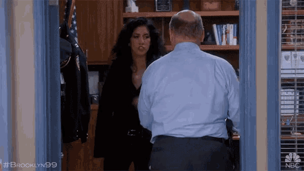 a man and a woman are standing in a doorway with brooklyn99 written on the bottom