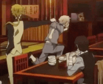 a group of people are sitting at tables in a restaurant and a man is pointing at another man .