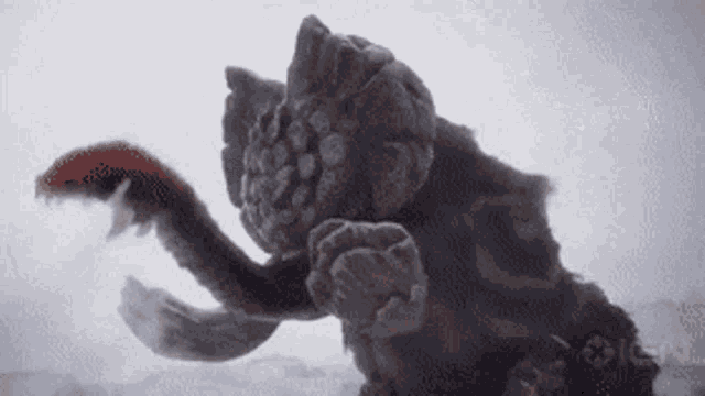 a close up of a monster with a long tail and claw .