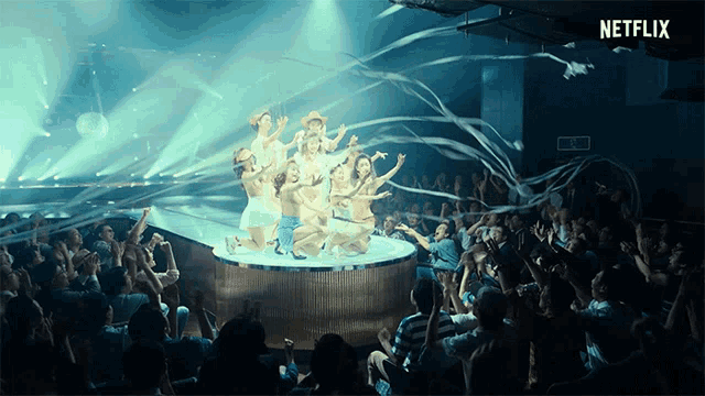 a group of people dancing in front of a crowd with a netflix logo in the corner