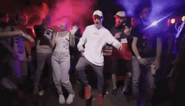 a man is dancing in front of a crowd of people in a club .