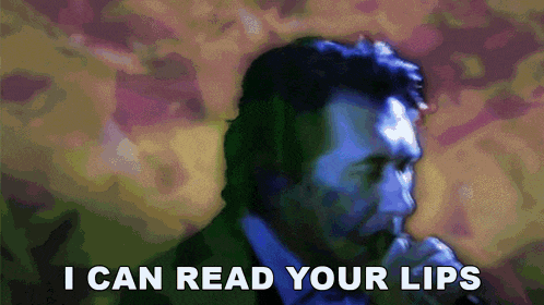 a man singing into a microphone with the words " i can read your lips " above him
