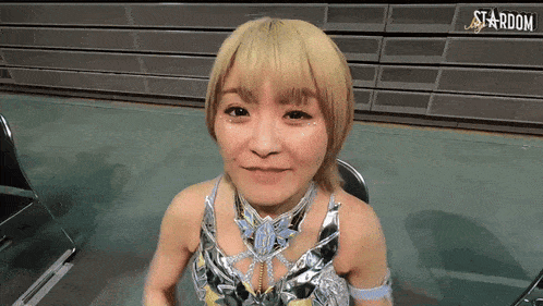 a woman is smiling in front of a wall that says stardom