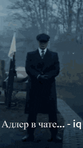 a man in a suit and tie stands in front of a sign that says " adler in chate ... iq "
