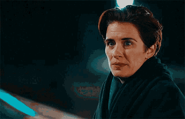 a woman with short hair is wearing a black scarf