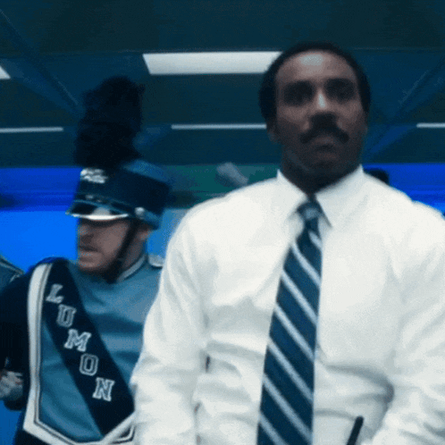a man in a white shirt and blue tie is standing next to a man in a blue uniform with the word lemon on it