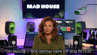 a woman is sitting in front of a mad house sign