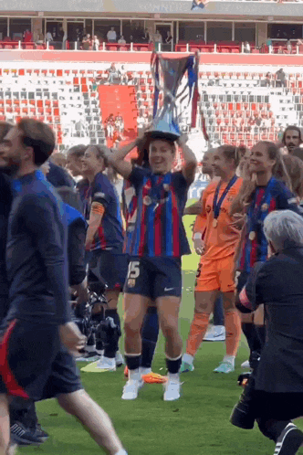 a soccer player with the number 15 on her jersey holds a trophy