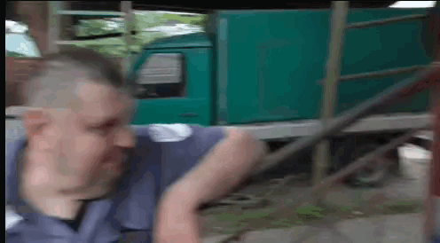 a man is standing in front of a green truck