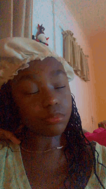 a young girl wearing a shower cap with her eyes closed .