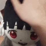 a person is putting their hand on a stuffed doll with red eyes .