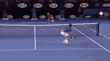 a man is playing tennis on a blue court with kia advertisements behind him