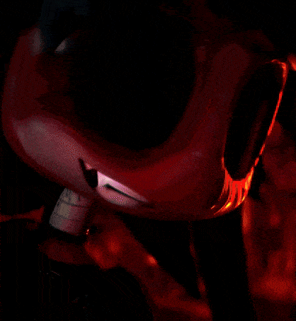 a yellow light is shining on a red object in a dark room
