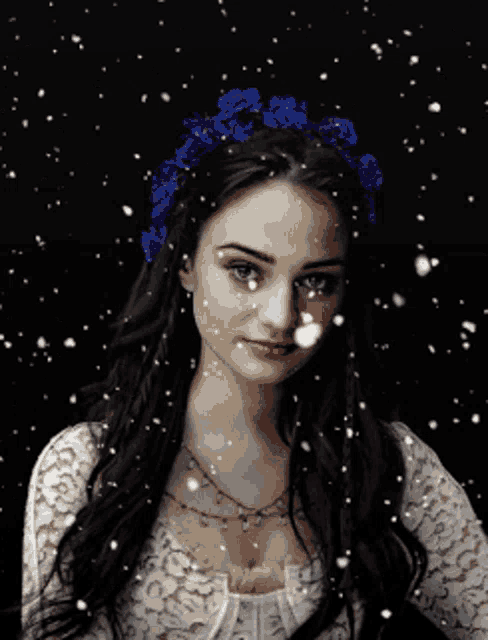 a woman with a flower crown on her head is surrounded by snow