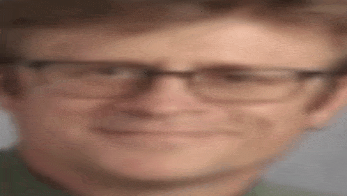 a close up of a man wearing glasses making a face .