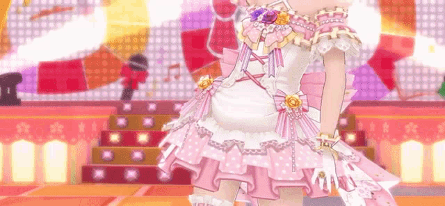 a girl in a pink dress is standing on a stage .