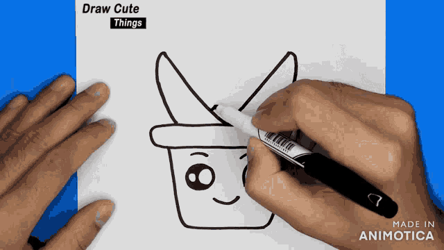 a person is drawing a bunny with a hat on a piece of paper