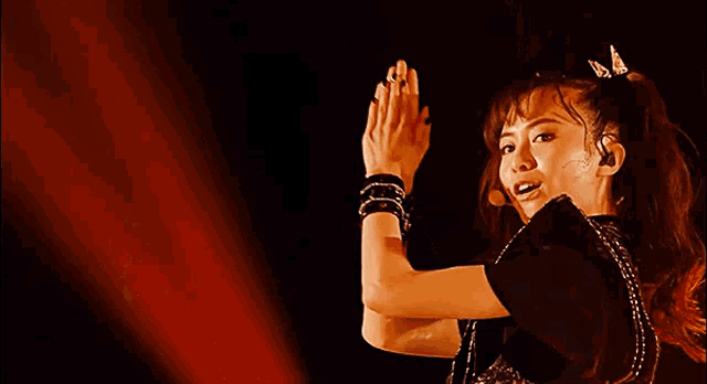 a woman is dancing with her arms in the air and a butterfly in her hair .