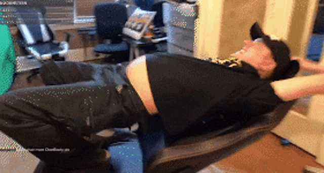 a man is laying in a chair with his arms outstretched