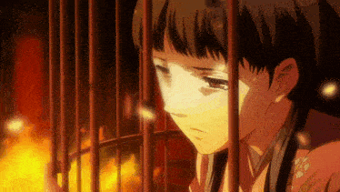a girl in a cage with fire behind her