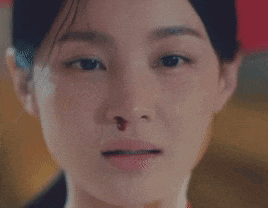 a close up of a woman 's face with her eyes closed and a tear running down her cheek .