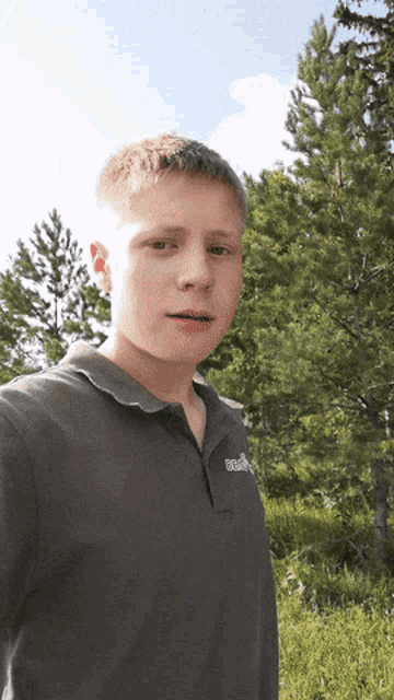 a young man wearing a gray shirt with the word columbia on it