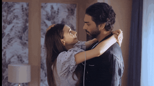 a man and a woman hugging each other in a room