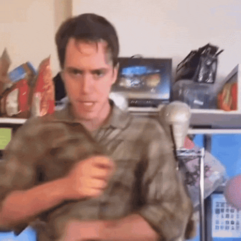 a man in a camouflage shirt stands in front of a microphone