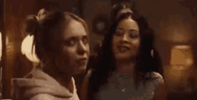 a group of women are standing next to each other in a room and talking .