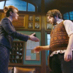 a man and a woman are shaking hands in front of a window