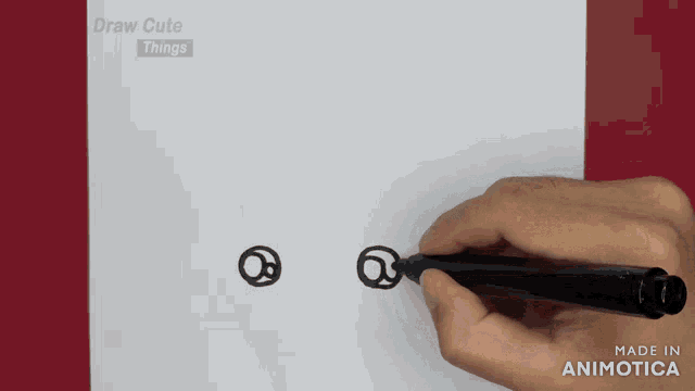 a person is drawing two circles on a piece of paper with the words draw cute things behind them