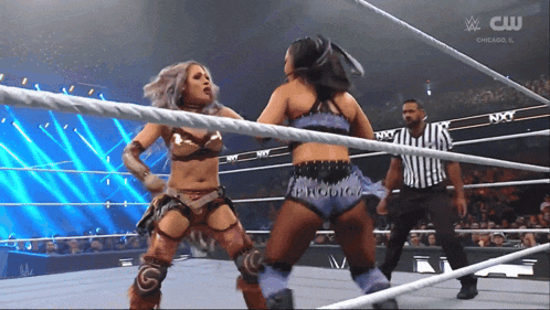 two women are wrestling in a ring with the words nxt on the ropes behind them