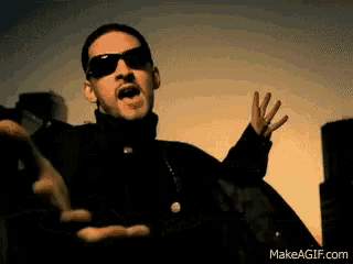 a man wearing sunglasses is making a funny face